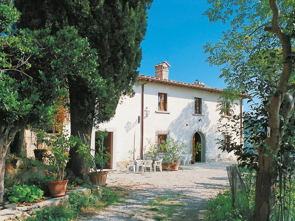 a white house with trees and chairs in front of it at Holiday Home Chiesa by Interhome in Linari