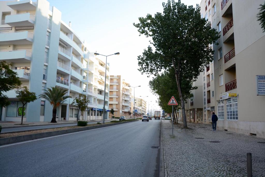 a man walking down a city street with buildings at Casa Fragata B in Armação de Pêra