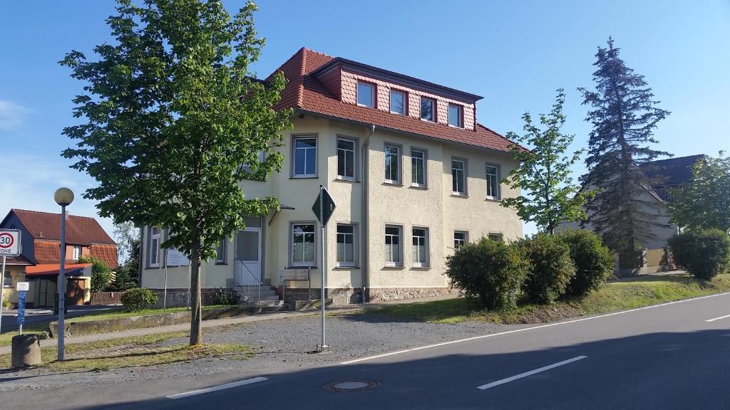 a white house with a red roof on a street at Harzquartier in Friedrichsbrunn