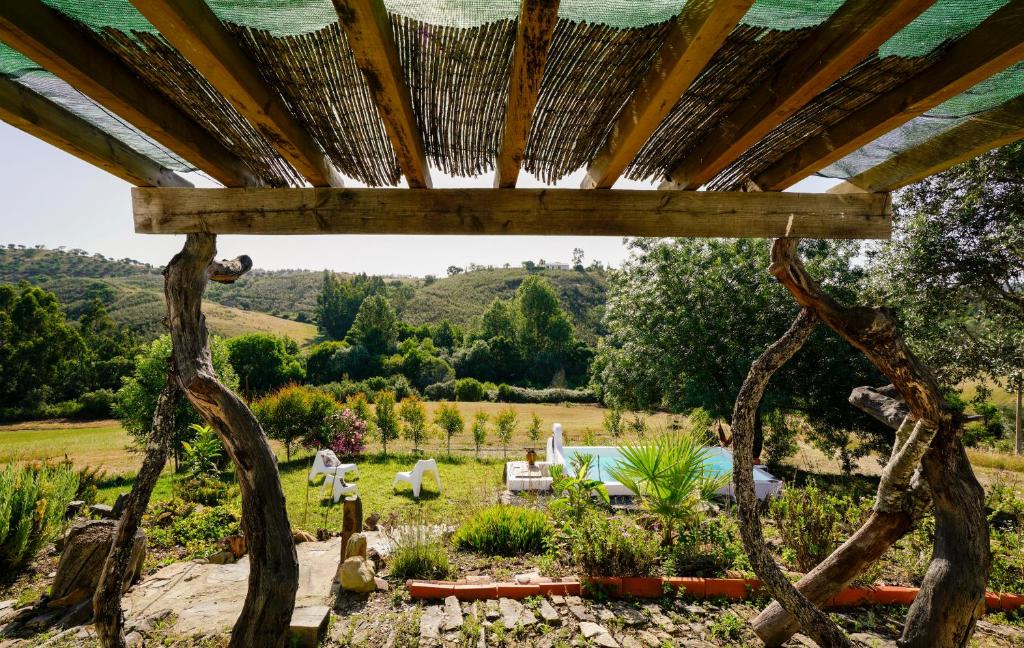 a view of a garden with a pergola at The Stream House - Montes da Ronha in Zambujeira do Mar