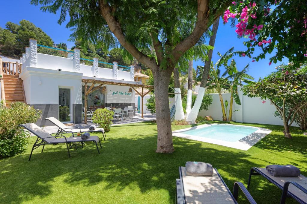 un cortile con un albero e una piscina di Villa El Ranchito By Seric, 15' walking to the beach a Torremolinos