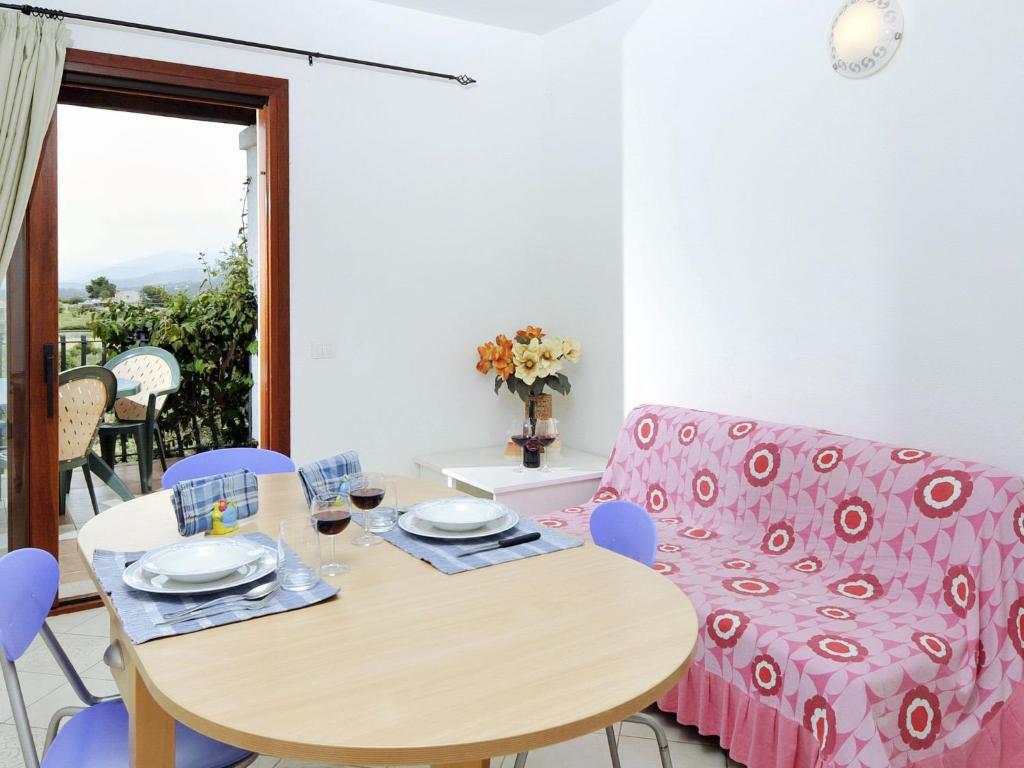 jadalnia ze stołem i różową kanapą w obiekcie Apartment L'Uddastru trilo by Interhome w mieście San Teodoro