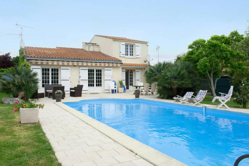 uma piscina em frente a uma casa em Villa de 4 chambres avec piscine privee jardin clos et wifi a Aytre a 5 km de la plage em Aytré