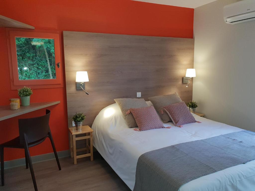 ein Schlafzimmer mit einem Bett mit einer orangefarbenen Wand in der Unterkunft Domaine du Surgié in Figeac