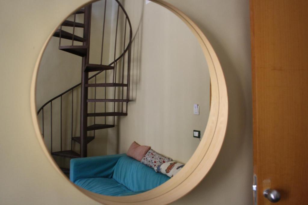 een spiegel met een blauwe bank voor een trap bij 3D House Catania centro in Catania