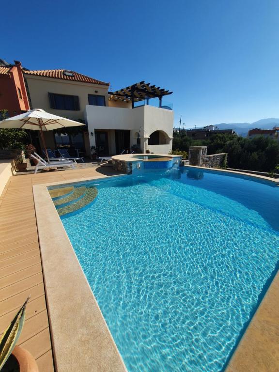 a swimming pool in front of a house at Villa Azure Sea, Istron in Istro