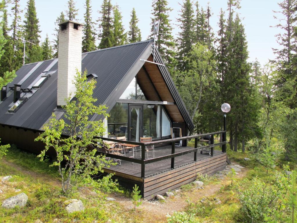 a cabin in the woods with a black roof at Chalet Lofsdalen Fjällbjörken - HJD054 by Interhome in Lofsdalen