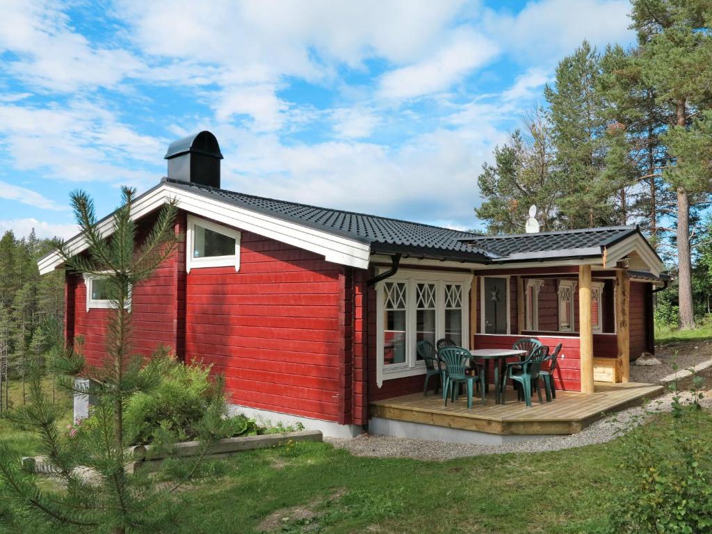 a red tiny house with a deck and a table at Chalet Kvisthån Idegranen - HJD059 by Interhome in Vemhån