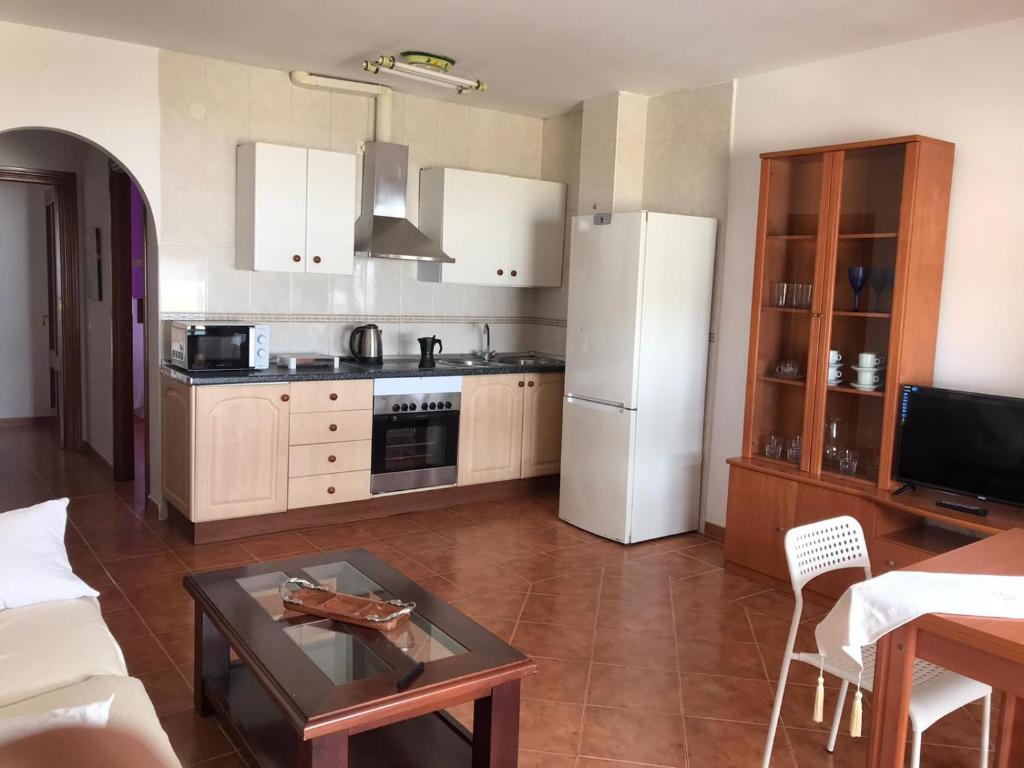 een keuken met een witte koelkast en een tafel bij Apartamento en Fuengirola junto al paseo marítimo in Fuengirola