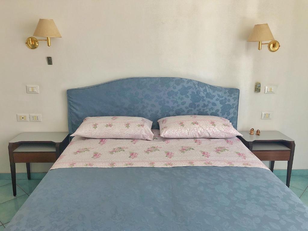 un letto blu con due cuscini sopra di Residenza Celeste al 28 a Ischia