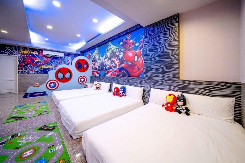 two beds in a room with a superhero mural at 樂哈哈羅東夜市親子民宿 in Luodong