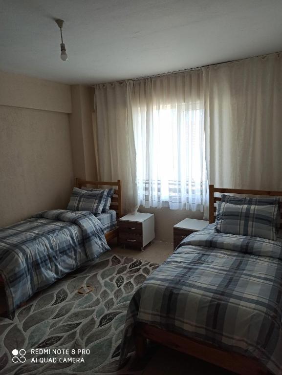 a hotel room with two beds and a window at Denize sıfır 3+1 daire (D/5) in Tekirdag