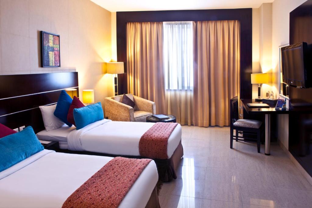 Postel nebo postele na pokoji v ubytování Landmark Riqqa Hotel