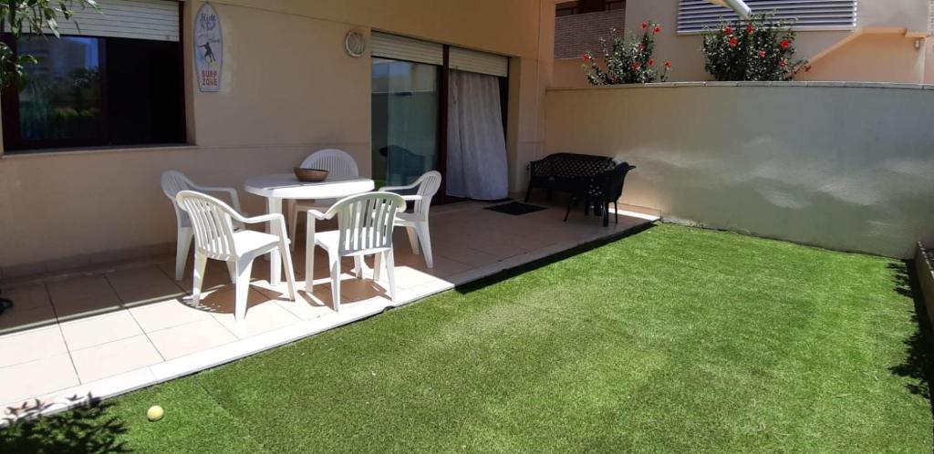 a small backyard with a table and chairs and grass at Mediterranea in La Pineda