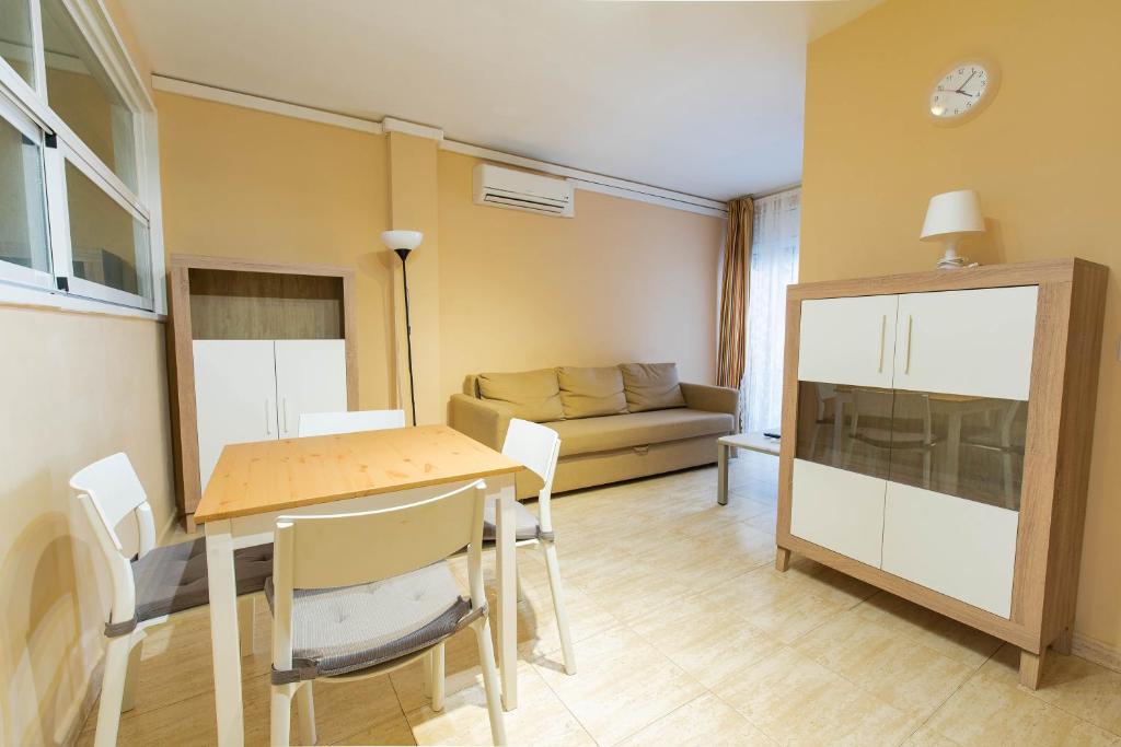 ein Wohnzimmer mit einem Tisch und einem Sofa in der Unterkunft Apartaments Costamar Calafell in Calafell