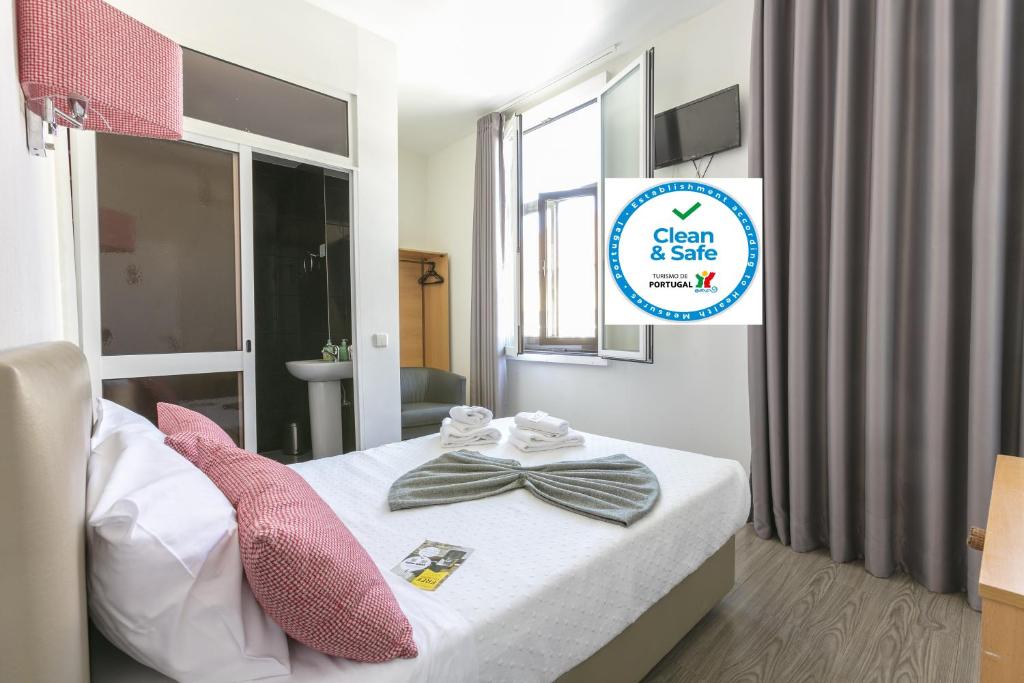 a bedroom with a bed with a bow tie on it at Guest House Porto Clerigus in Porto