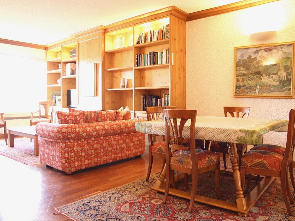 ein Wohnzimmer mit einem Tisch, Stühlen und einem Sofa in der Unterkunft Central & Spacious | Ambassadeurs A in Crans-Montana