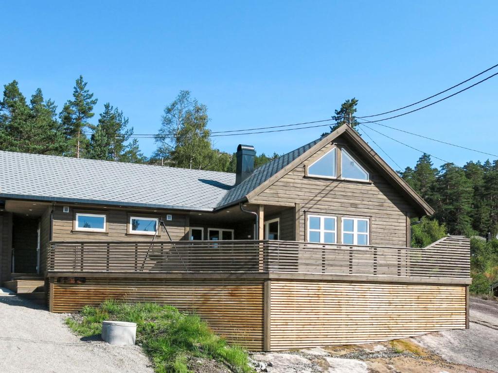 una casa de madera con una gran terraza de madera en Chalet Doghouse - SOW048 by Interhome, en Øyuvstad