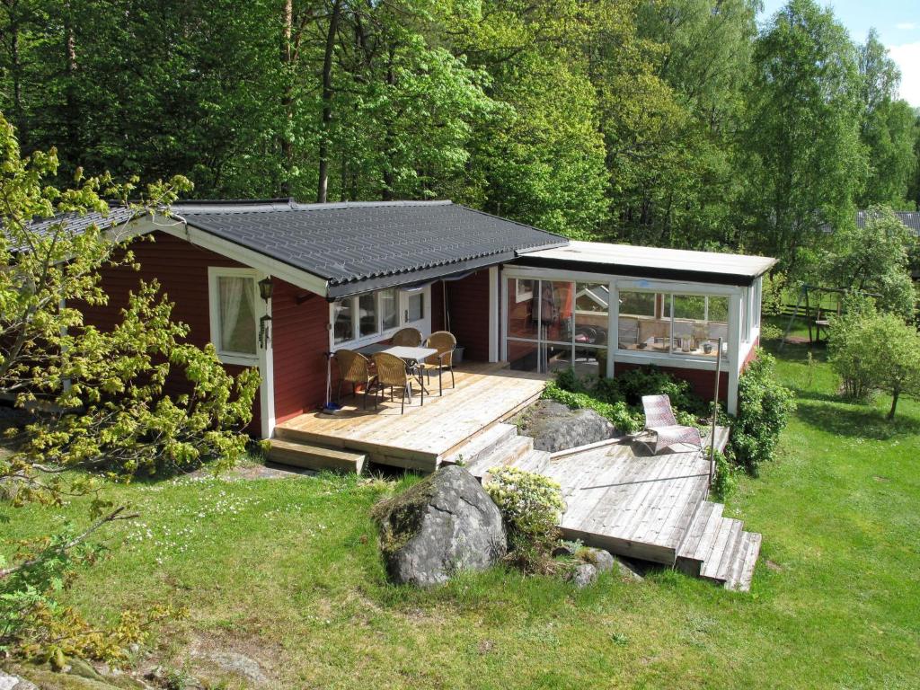 uma pequena cabina com um deque de madeira na relva em Holiday Home Munkhalla Morgonsolen by Interhome em Asarum