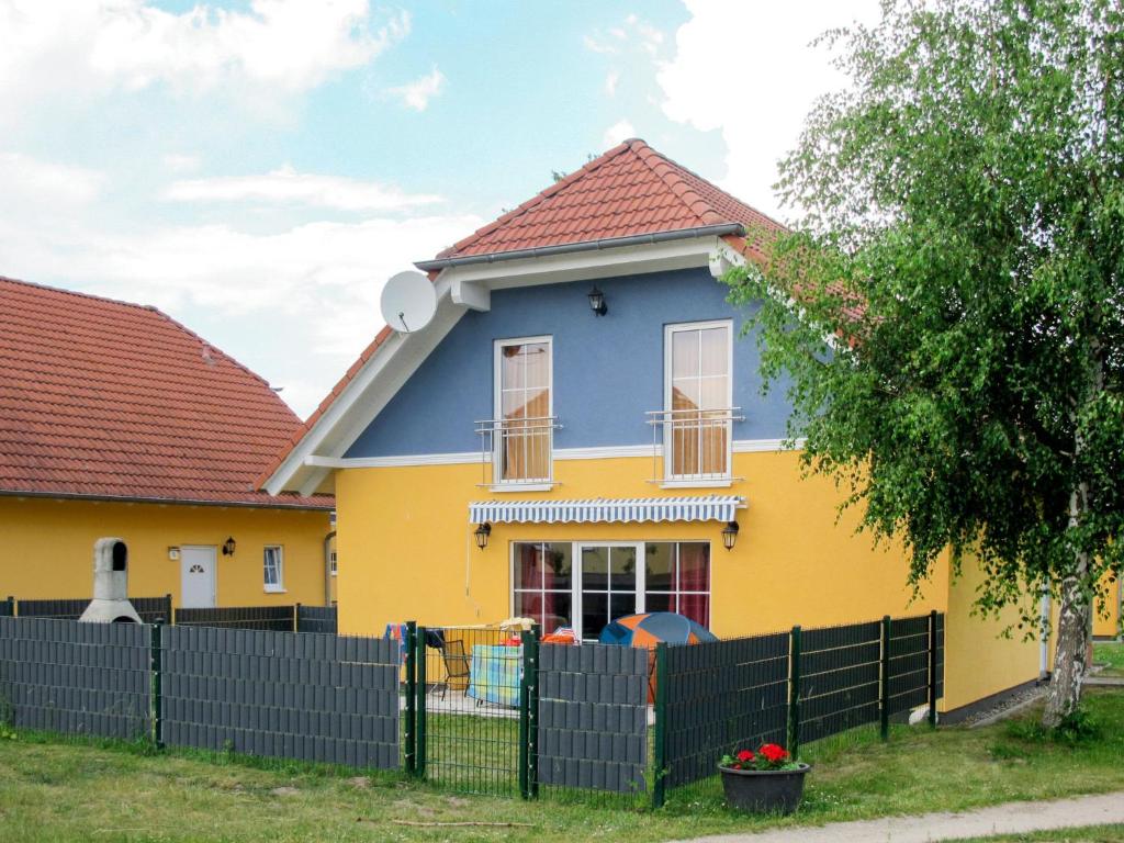 a yellow and blue house with a black fence at Holiday Home Ferienpark Verchen-3 by Interhome in Verchen