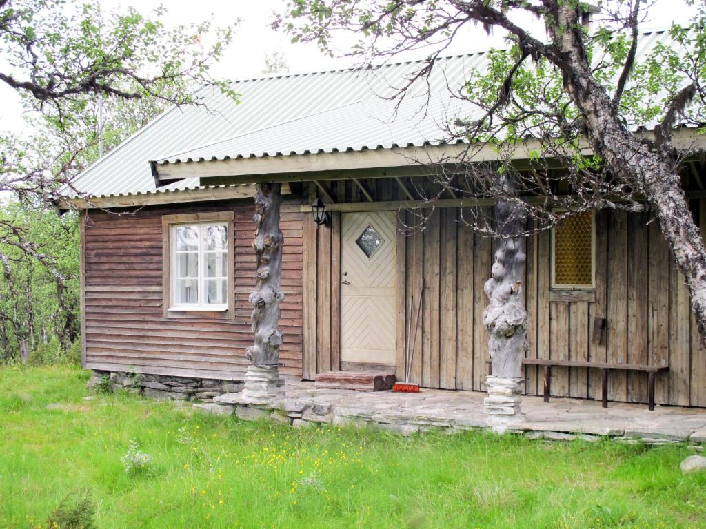 a small wooden house with a white door at Chalet Storsätern Dyllen - DAN080 by Interhome in Idre