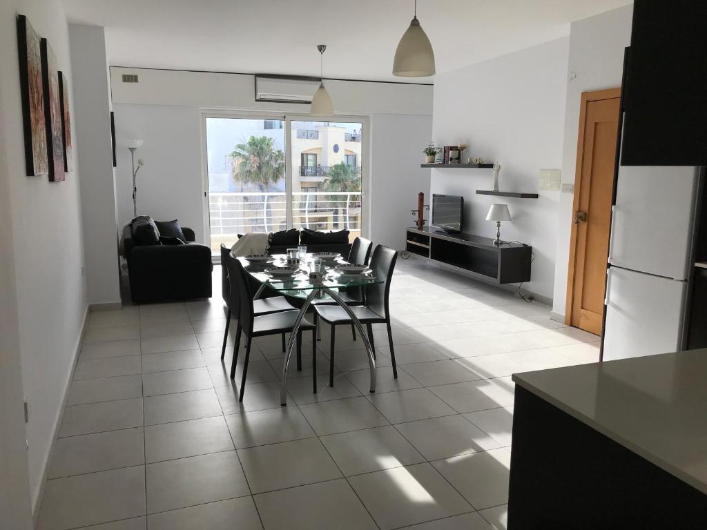 a kitchen and living room with a table and chairs at Ocean Pearl Apartment no4 in St. Paul's Bay