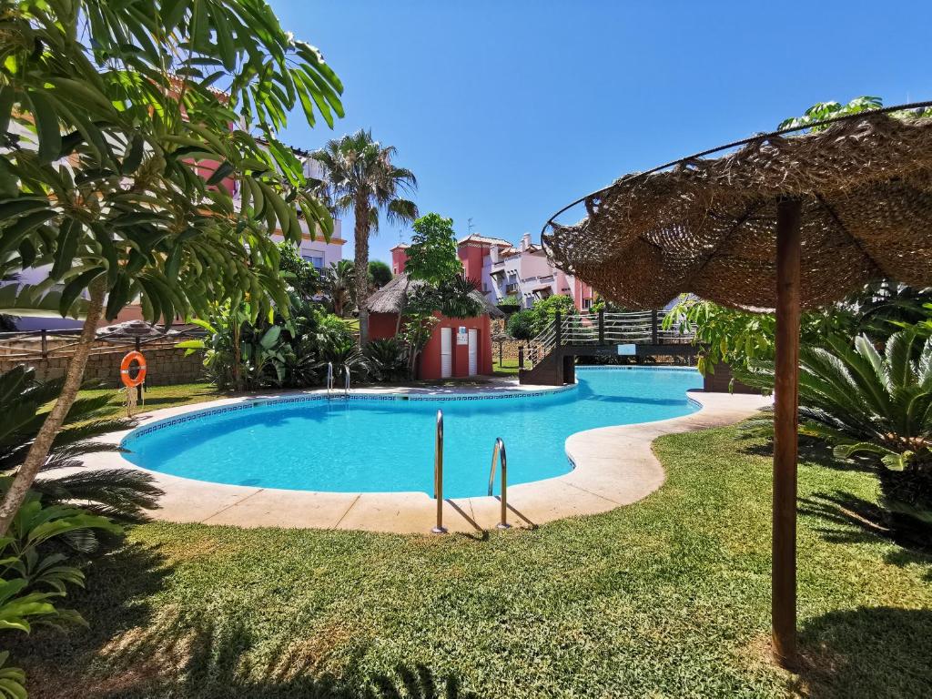 una piscina en un patio con sombrilla en Apartamento Hierro 9 Golf, en Caleta de Vélez