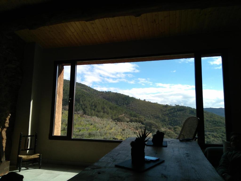 a room with a large window with a view of a mountain at La Chocita de Tio Castor in Ovejuela