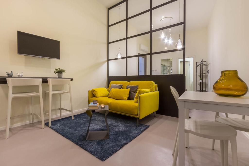 uma sala de estar com um sofá amarelo e uma mesa em Suite Cagliari -97- em Cagliari