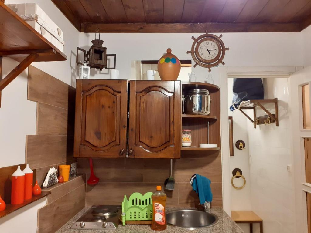 una cucina con mobili in legno e un lavello di La tana del porto a Napoli