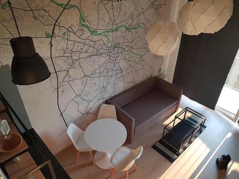 uma sala de estar com um sofá, uma mesa e cadeiras em Apartament Atram Minimax em Breslávia