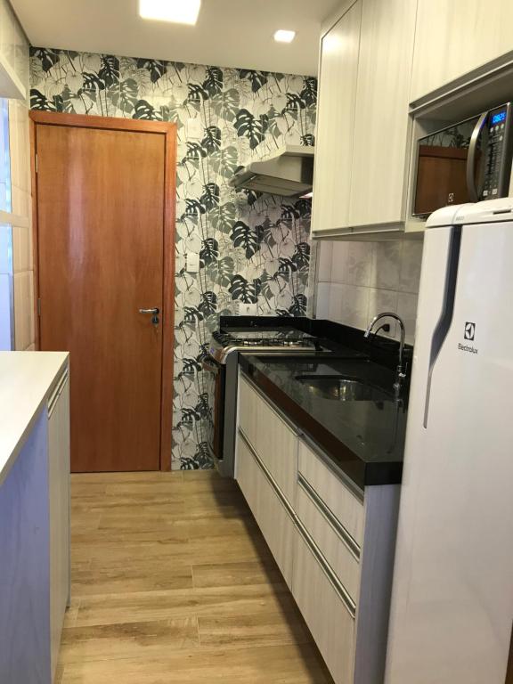 cocina con fregadero y nevera en Liberdade 1 QT + Sofá Cama - 200m Metrô. Novo!, en São Paulo