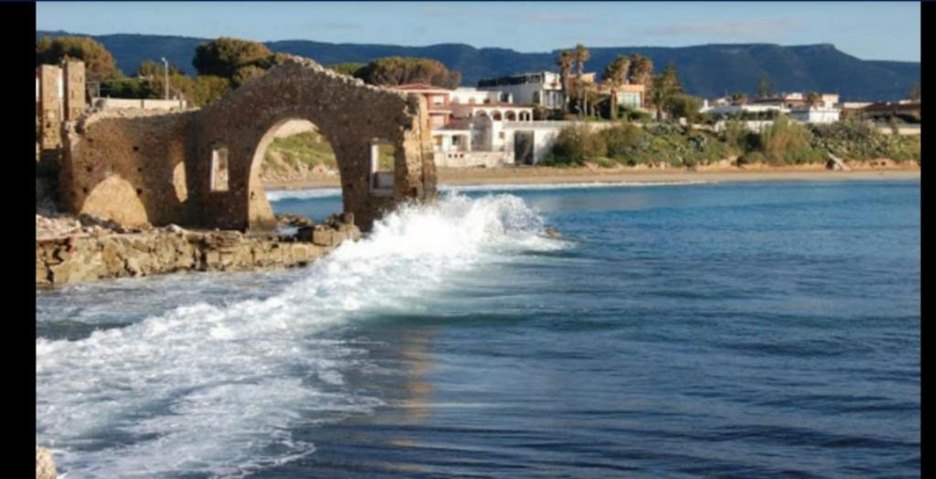 un viejo puente sobre un cuerpo de agua en La Scogliera, en Avola