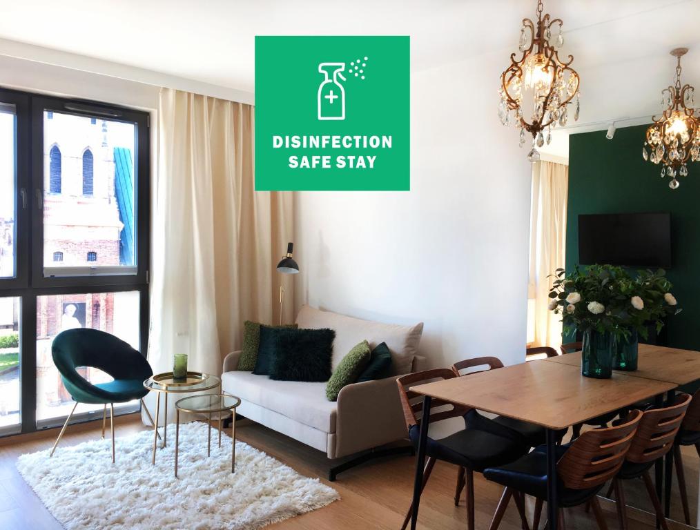 a living room with a couch and a table at Green Apartment Gdańsk z GARAŻEM in Gdańsk