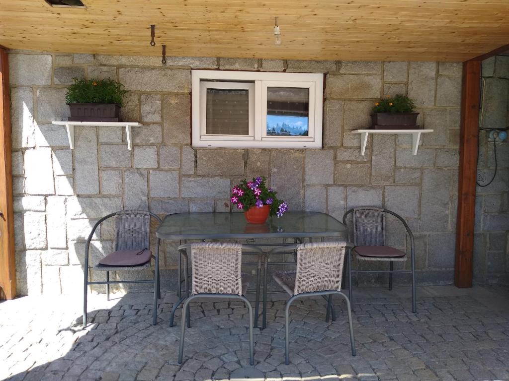 a glass table and chairs on a patio at Apartmán Pavla in Ostružná