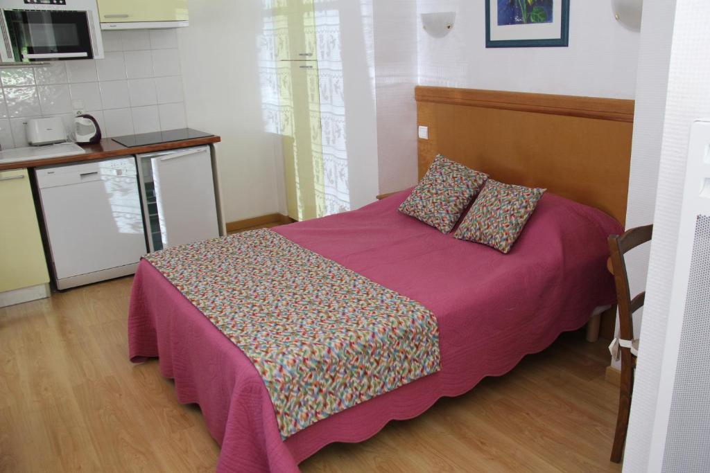 - une petite chambre avec un lit et une couverture violette dans l'établissement VILLA ASTAY, Studio No. 3 - Rez de chaussée, à Aix-les-Bains