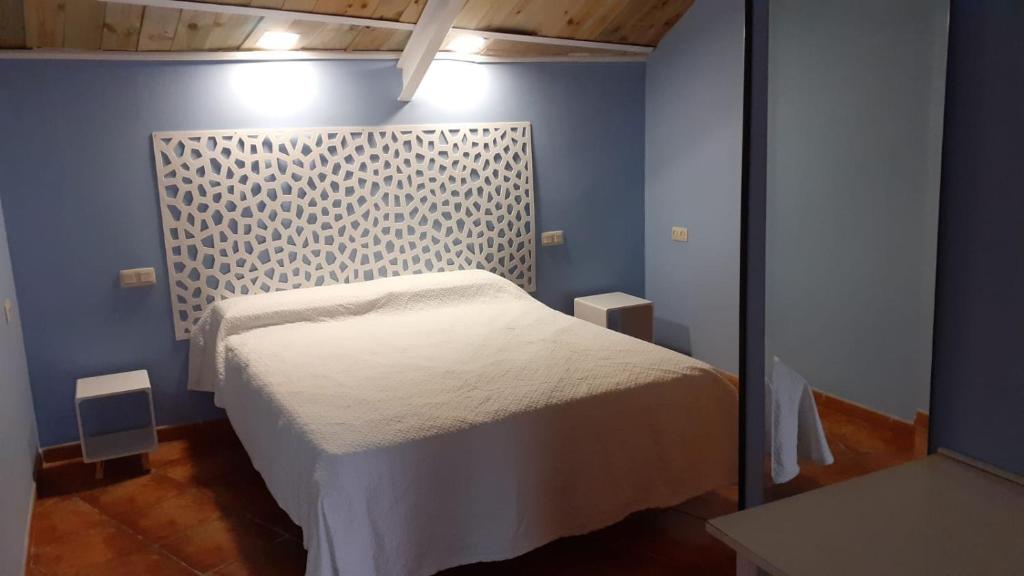 a bedroom with a white bed in a blue wall at Casita para dos con piscina privada in Torres