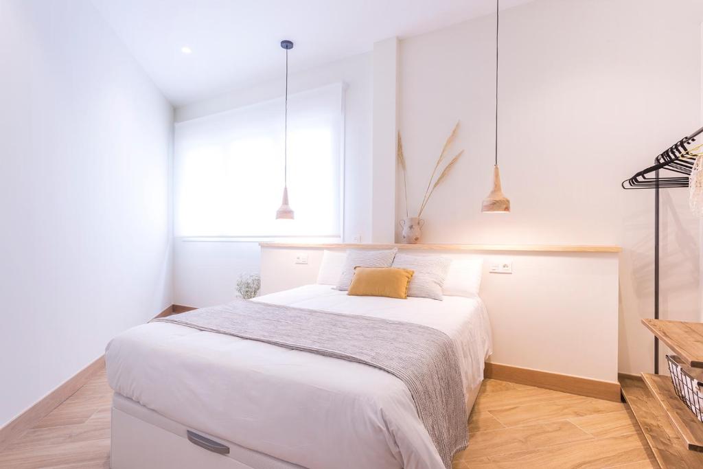 a bedroom with a large white bed in a room at GETARIA APARTAMENTUAK - Balentziaga in Getaria