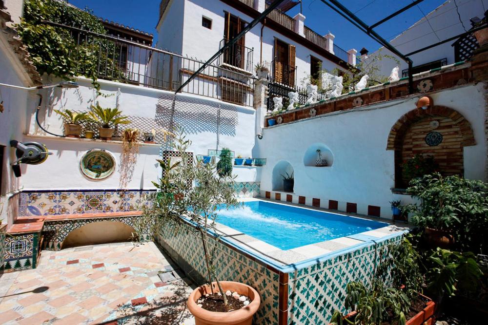 um pátio com uma piscina numa casa em Oripando Hostel em Granada