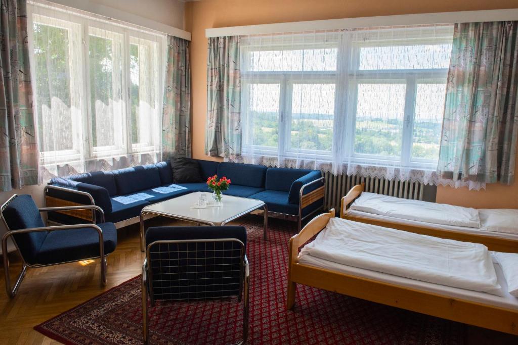 Zimmer mit 2 Betten, einem Sofa und einem Tisch in der Unterkunft Sola Gratia in Bystřice pod Hostýnem