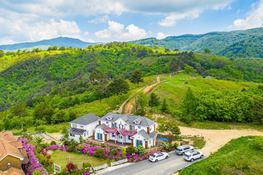 an aerial view of a house with cars parked in the driveway at Pungcha & Herb Pension in Pyeongchang
