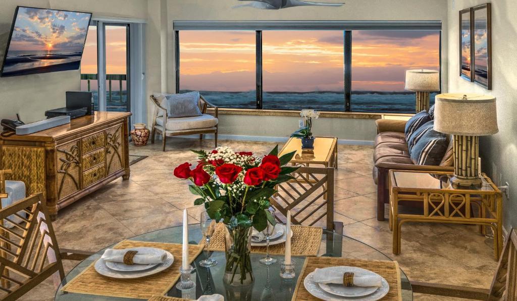 una sala de estar con un jarrón de flores sobre una mesa en Amelia Island Oceanfront Condo en Amelia Island