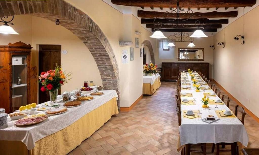 grupa stołów z talerzami żywności na nich w obiekcie Agriturismo Castello La Grancia di Spedaletto w mieście Pienza