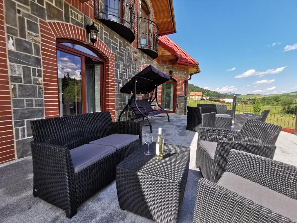 un patio con sillas de mimbre y una mesa en Zamoček en Matiašovce