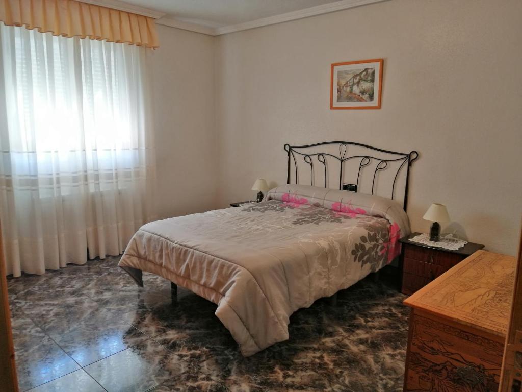 Schlafzimmer mit einem Bett und einem Fenster in der Unterkunft Casa Rural Amelia in Cepeda