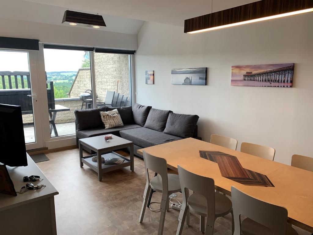 a living room with a couch and a table at TERRASSES DE MALMEDY Triplex 259 " C EST LA VIE " in Malmedy