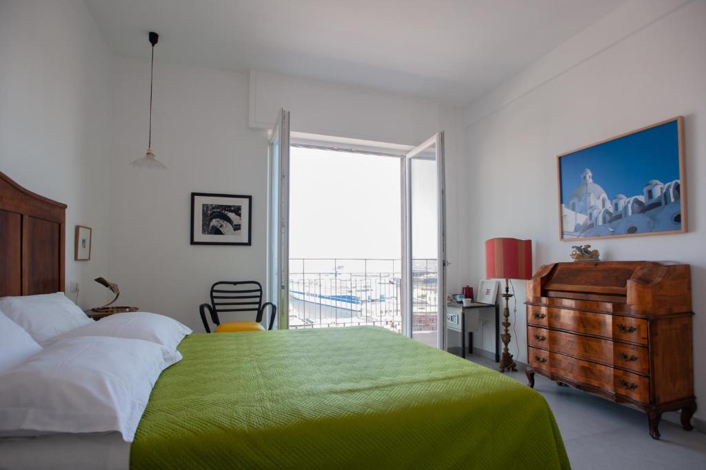 ein Schlafzimmer mit einem grünen Bett und einem großen Fenster in der Unterkunft B&B ICHOME NAPOLI - Maison d'Artiste in Neapel