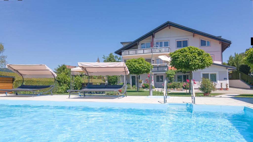 a house with a swimming pool in front of a house at Apartments Jernej am Turnersee in Sankt Kanzian