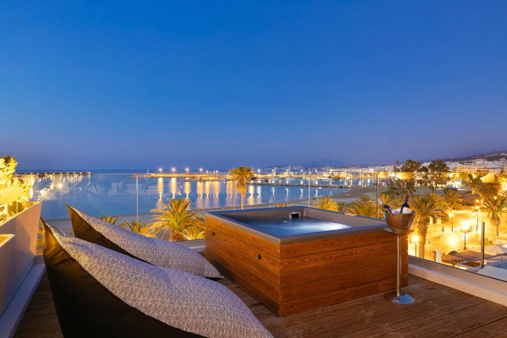 bañera de hidromasaje en el balcón con vistas al agua en Μuses Suites en Rethymno