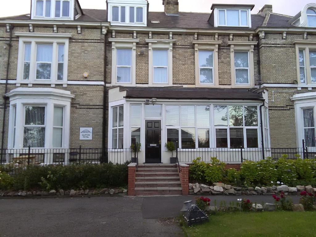 a large brick house with white windows at Clifton Hotel & Bar Newcastle in Elswick